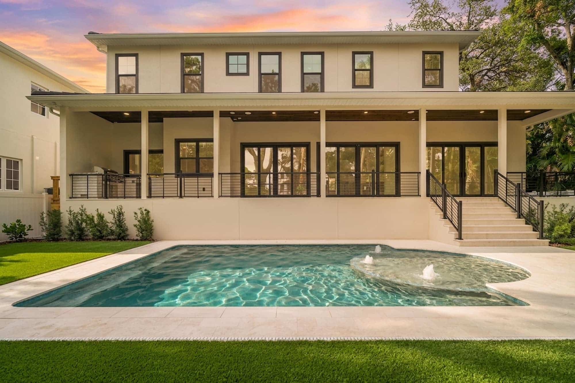 LIV Pools custom pool with sun shelf bubblers behind a modern Tampa Bay home